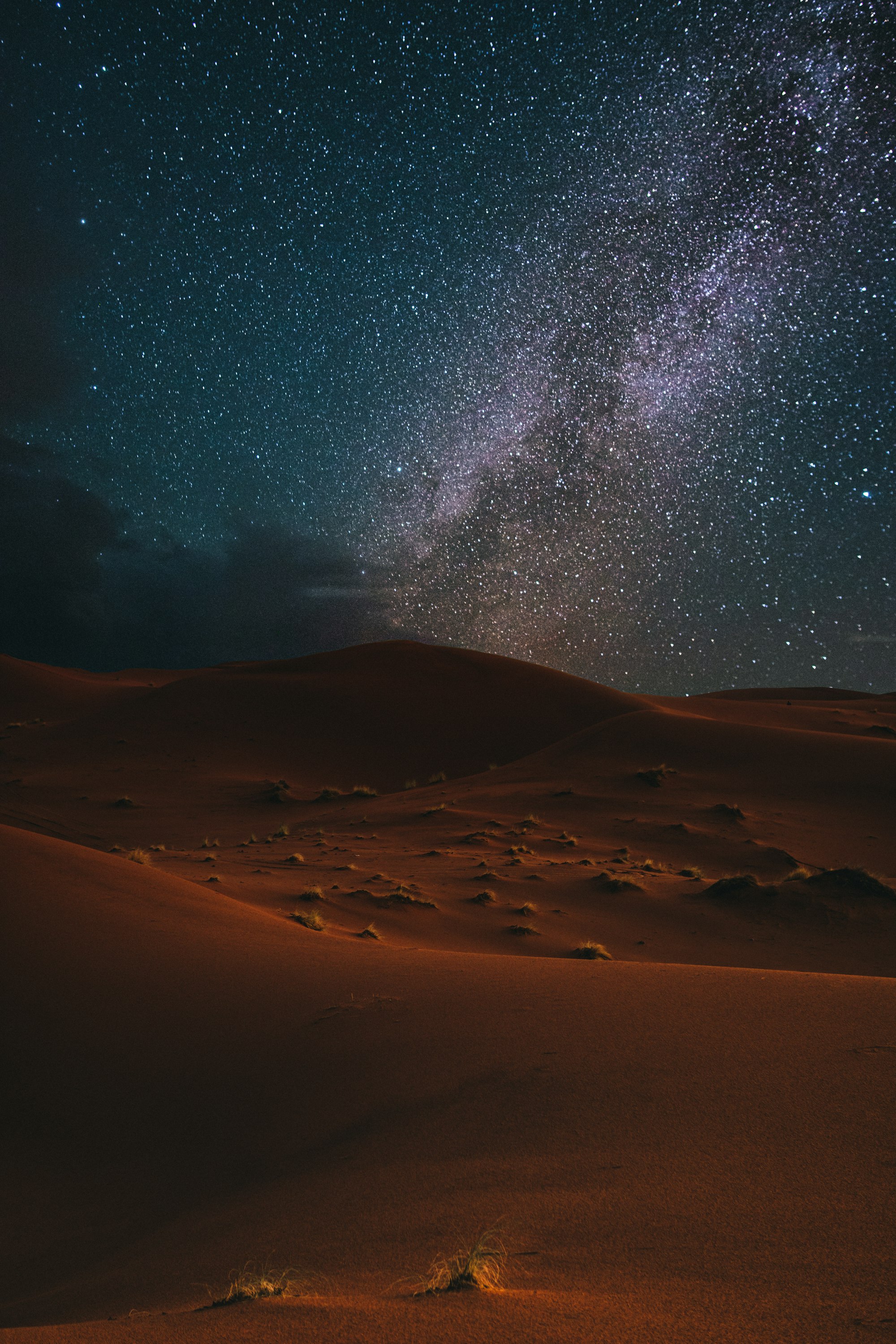 Orange desert dunes under the Milky Way