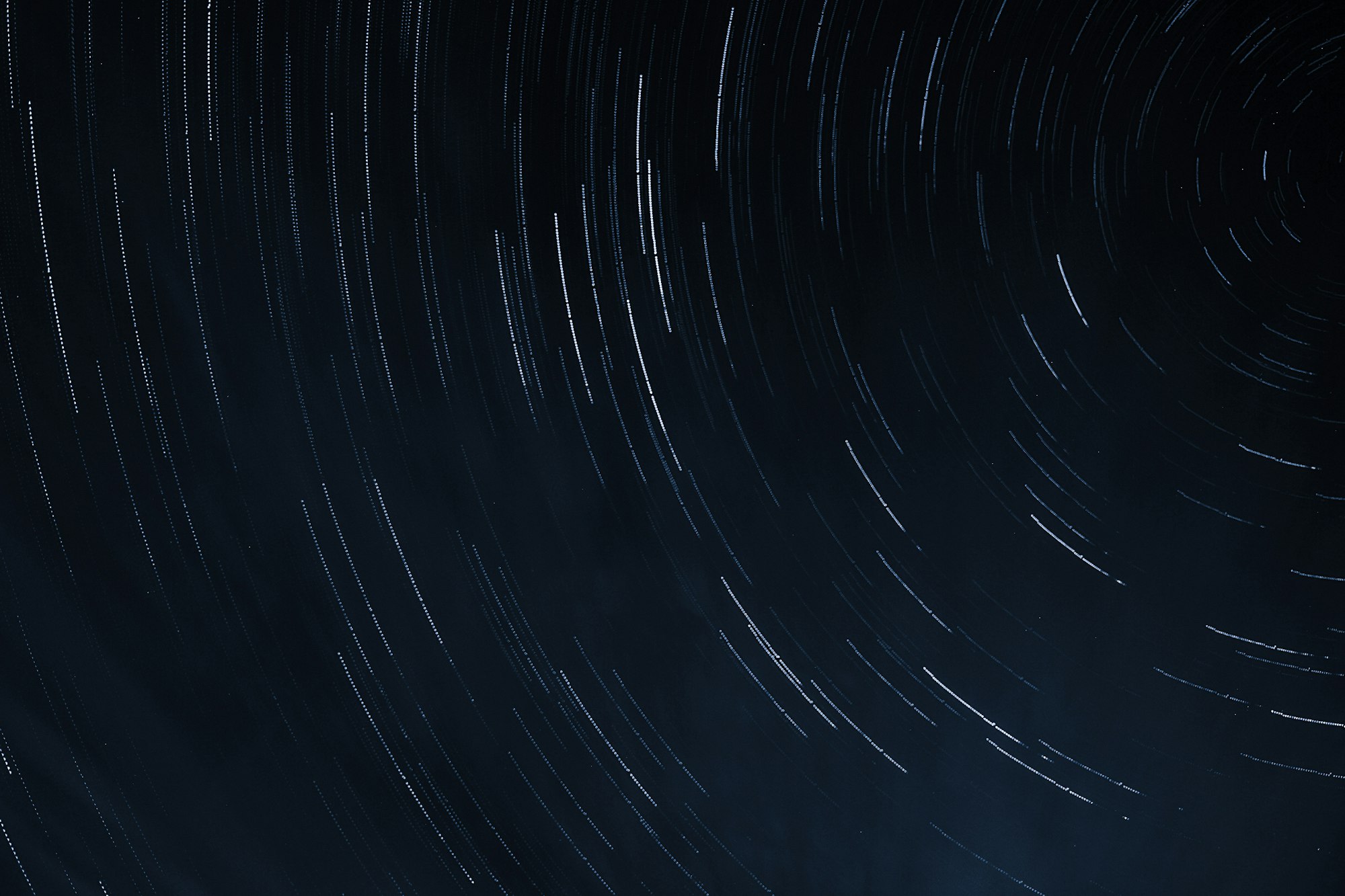 Star trails arcing across a black night sky in a long exposure